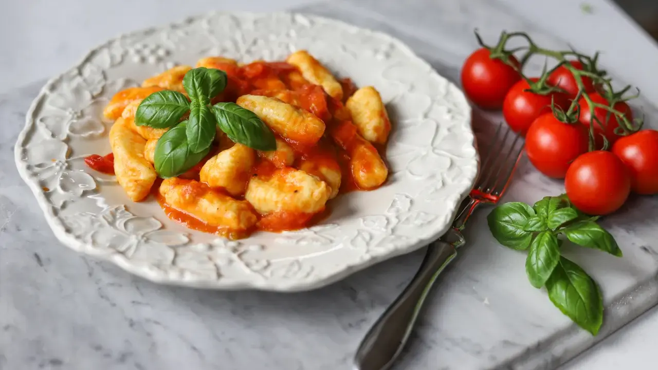 Pyszne gnocchi w sosie pomidorowym, ozdobione bazylią. Idealne na szybki obiad. Gnocchi przepis z czym podawać? Z pomidorami i bazylią!