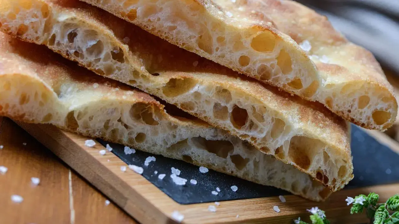 Puszysta focaccia z chrupiącą skórką, posypana solą. Idealny przepis na domową focaccię.