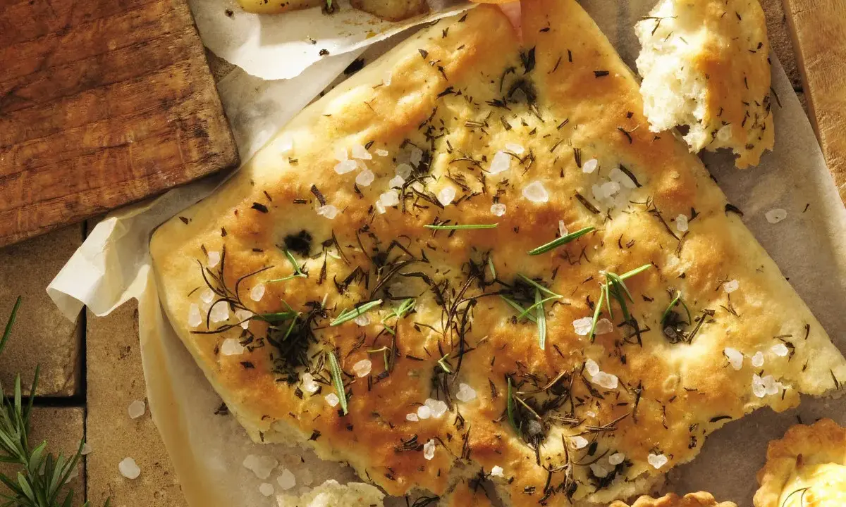 Chrupiąca focaccia z rozmarynem i solą morską, idealna do podania z pieczonymi ziemniakami i wędliną.