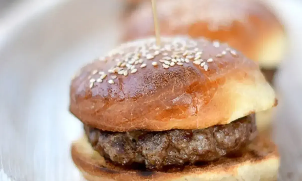 Mini burgery na talerzu, z sezamem na wierzchu. Idealne bułki do burgerów na przyjęcie.