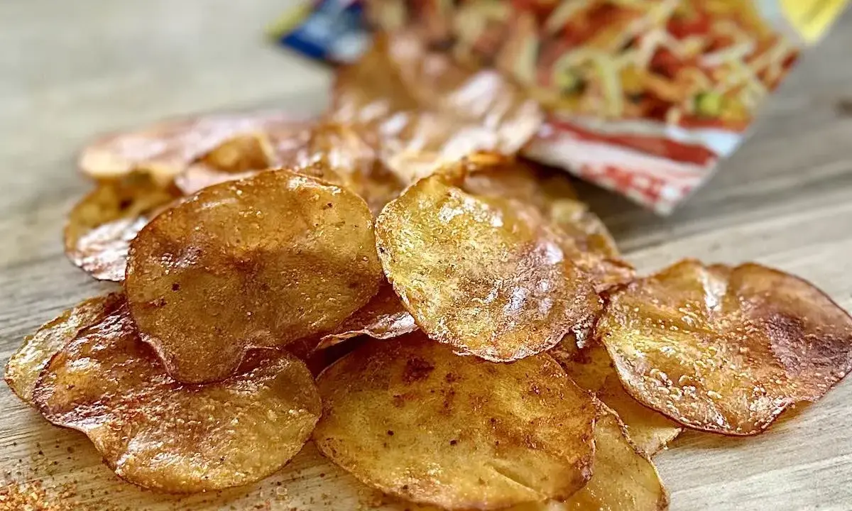 Chrupiące chipsy z piekarnika, lekko przypieczone, z widocznym opakowaniem w tle. Idealna przekąska!