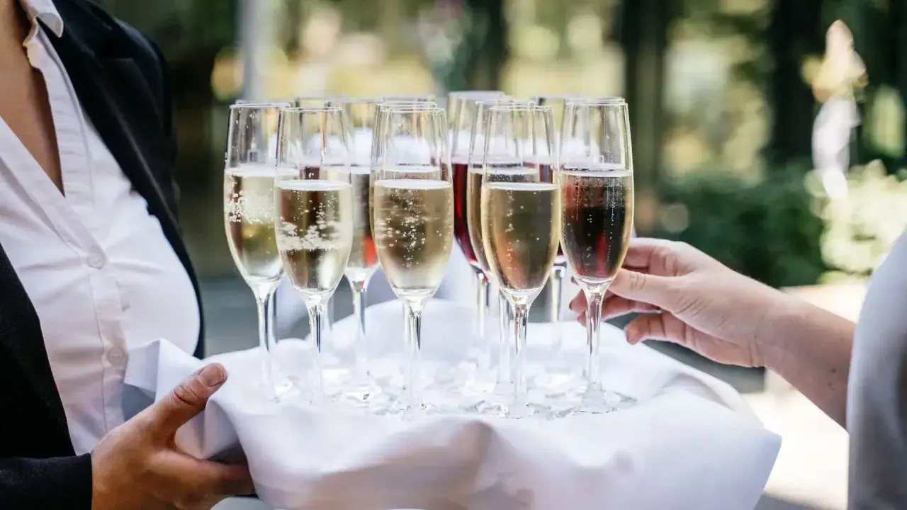 Taca z kieliszkami musującego wina, idealna do drinków typu Hugo. Zastanawiasz się, jakie prosecco do Hugo wybrać?