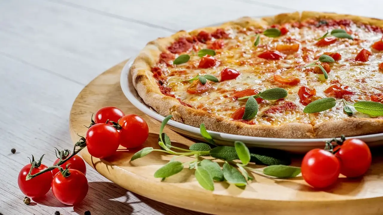 Pyszna pizza z pomidorkami i szałwią. Idealne jakie przyprawy do pizzy? Świeże zioła i pieprz.