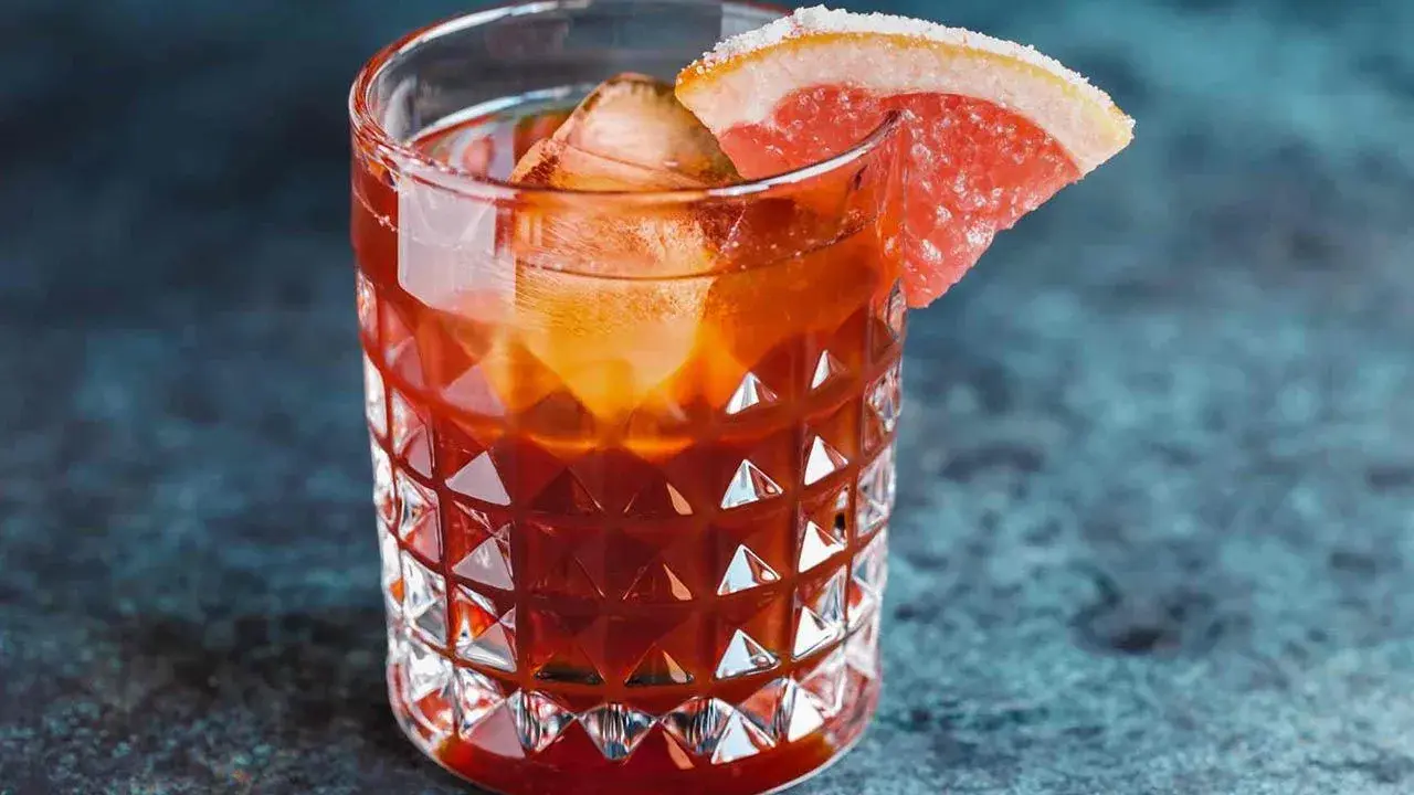Jägermeister z colą w szklance z lodem i plasterkiem grejpfruta. Idealny na wieczorne orzeźwienie.