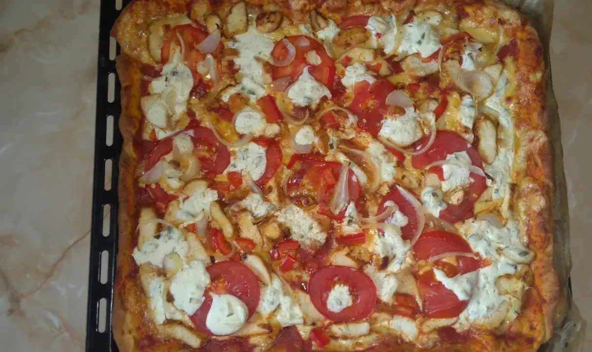 Pyszna, prostokątna pizza bez drożdży z kurczakiem, pomidorami, cebulą i serem.