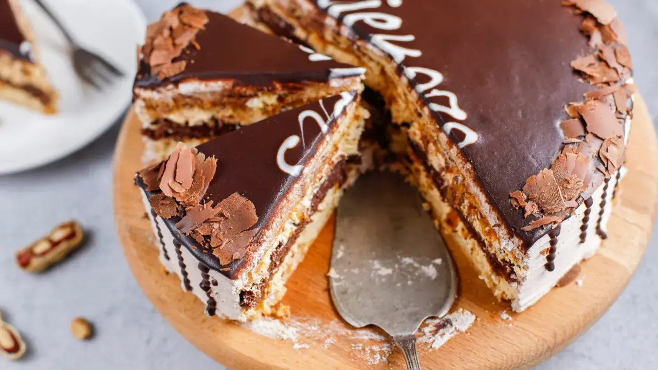 Pyszne snickers ciasto z czekoladą i orzeszkami, pokrojone na kawałki, gotowe do podania.