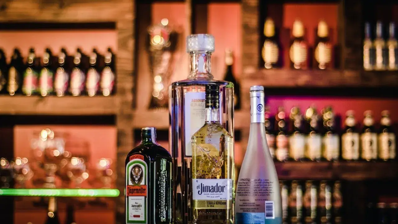 Jägermeister z sokiem jabłkowym i innymi alkoholami na barze.