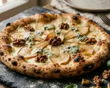 Wykwintna pizza bianca z gruszką, orzechami włoskimi i serem pleśniowym, idealna na wyjątkowy wieczór.