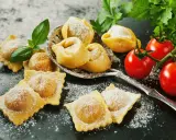 Świeże ravioli i tortellini, posypane cukrem pudrem, z pomidorkami koktajlowymi i bazylią. Idealne z czym podawać ravioli? Z prostym sosem!