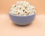 Pyszny, puszysty popcorn w niebieskiej misce. Idealny, gdy zastanawiasz się, jak zrobić popcorn na wieczór filmowy.