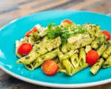 Penne z kurczakiem i pomidorkami koktajlowymi w sosie pesto, z dodatkiem mozzarelli.