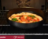 Pizza z pomidorami i bazylią piecze się w piekarniku. Idealna do pizzy, ta patelnia zapewni chrupiący spód.
