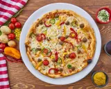 Pizza z mięsem mielonym, papryką, cebulą i kukurydzą. Obok sosy i warzywa, co zamiast śmietany?