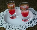 Dwa kieliszki z czerwonym drinkiem, ozdobione złotym wzorem. Wyglądają jakby miały moc, niczym wściekły pies drink.