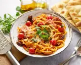 Pyszny makaron z chorizo, pomidorkami koktajlowymi i świeżą bazylią, posypany parmezanem. Idealny na szybki obiad.