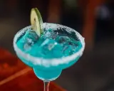 Orzeźwiający drink bezalkoholowy z blue curacao, lodem i plasterkiem limonki, z cukrowym rantem.