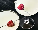 Dwa eleganckie drinki z liczi, ozdobione owocami na patyczkach, kuszą swoim orzeźwiającym wyglądem.