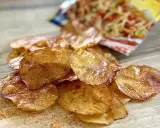 Chrupiące chipsy z piekarnika, lekko przypieczone, z widocznym opakowaniem w tle. Idealna przekąska!
