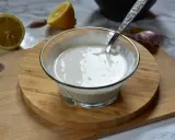 Kremowy sos aioli w szklanej miseczce, obok cytryny i czosnku. Idealny dodatek do dań.
