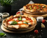 Dwie pyszne pizze, jedna margherita, druga z dodatkami. Idealne co do pizzy, by cieszyć się smakiem.