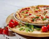 Pyszna pizza z pomidorkami i szałwią. Idealne jakie przyprawy do pizzy? Świeże zioła i pieprz.