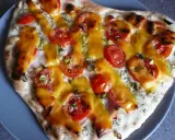 Pizza z pomidorami i serem, polana sosem śmietanowym.
