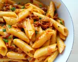 Penne z sosem z suszonych pomidorów i zieloną cebulką, apetyczne danie pełne smaku.