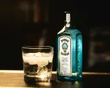 Szklanka z lodem i butelka Bombay Sapphire gin. Idealny składnik na orzeźwiający bombay sapphire drink.
