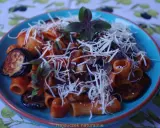 Rigatoni alla norma z bakłażanem, pomidorami i bazylią, posypane startym serem.