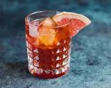 Jägermeister z colą w szklance z lodem i plasterkiem grejpfruta. Idealny na wieczorne orzeźwienie.