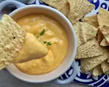 Chrupiące nachos zanurzane w kremowym, ciepłym sosie serowym. Idealna przekąska na imprezę.