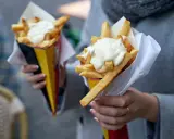 Dwie porcje chrupiących frytek w rożkach, polane obficie kremowymi sosami. Idealne na szybką przekąskę!