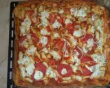 Pyszna, prostokątna pizza bez drożdży z kurczakiem, pomidorami, cebulą i serem.