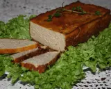 Pyszny pasztet drobiowy z wątróbką, pokrojony w plastry, podany na liściach sałaty. Idealny na kanapki.