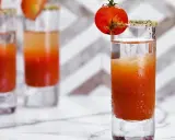 Trzy shoty z drinkiem, który wygląda jak przepis na to, jak zrobić wściekłego psa. Każdy ozdobiony pomidorkiem koktajlowym.