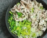 Na patelni pokrojone pieczarki i por, składniki na pyszny sos pieczarkowy przepis.