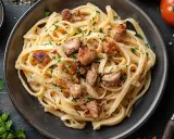 Pyszne fettuccine z kawałkami kurczaka i posiekaną natką pietruszki. Idealne co do spaghetti, gdy masz ochotę na coś sycącego.