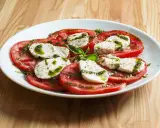 Sałatka caprese z pomidorów i mozzarelli, polana pesto. Idealne zdrowe przekąski na lato.