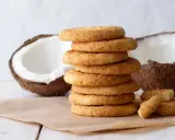 Stos ciastek z mąki kokosowej, obok połówki kokosa. Idealne na deser.
