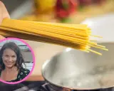 Uczymy się, ile gotować domowy makaron, by był idealny. Kobieta z uśmiechem trzyma pęczek spaghetti nad gotującą się wodą.