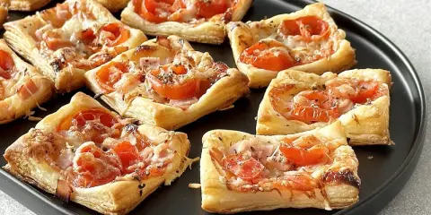 Pizzerinki z ciasta francuskiego z pomidorkami i serem. Idealne na szybką przekąskę.