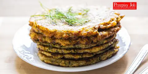 Stos placków z cukinii, idealnych jako dodatek do dania lub samodzielna przekąska. Ziołowy aromat i chrupiąca skórka zachęcają do spróbowania.