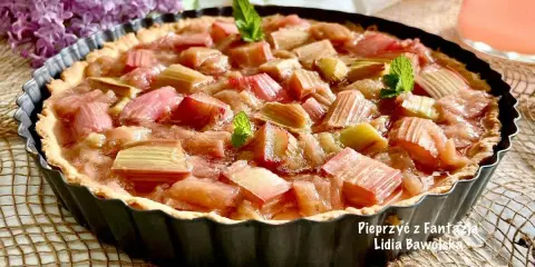Pyszna tarta z rabarbarem, udekorowana listkami mięty, kusi swoim wyglądem.