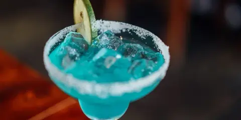Orzeźwiający drink bezalkoholowy z blue curacao, lodem i plasterkiem limonki, z cukrowym rantem.