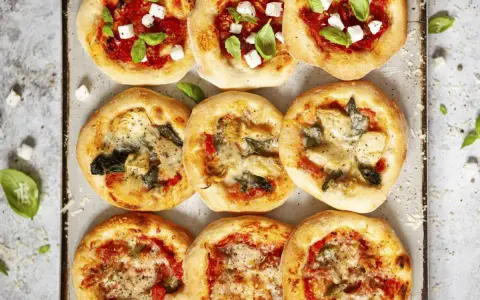Mini pizze z różnymi dodatkami: margherita, z fetą i bazylią, z karczochami i szpinakiem. Idealne, by pokazać, co zrobić z ciasta na pizzę!