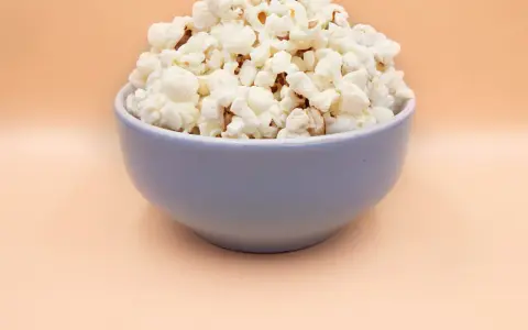 Pyszny, puszysty popcorn w niebieskiej misce. Idealny, gdy zastanawiasz się, jak zrobić popcorn na wieczór filmowy.
