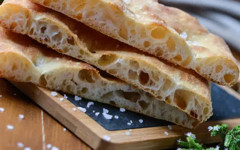 Puszysta focaccia z chrupiącą skórką, posypana solą. Idealny przepis na domową focaccię.
