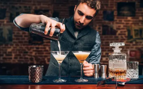 Barman przygotowuje drinki, zastanawiając się, jaki rum do mojito będzie najlepszy. Na blacie stoją kieliszki i karafka z bursztynowym płynem.