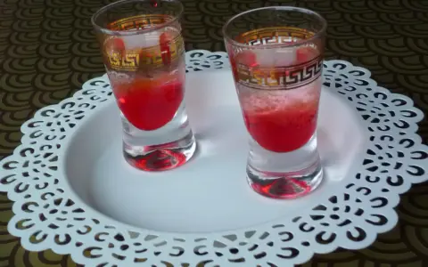 Dwa kieliszki z czerwonym drinkiem, ozdobione złotym wzorem. Wyglądają jakby miały moc, niczym wściekły pies drink.