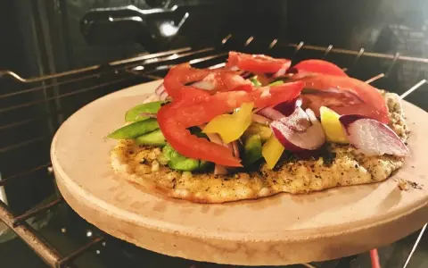 Pizza na kamieniu w piekarniku, z warzywami. Po pieczeniu, jak czyścić kamień do pizzy, by był gotowy na kolejne wypieki.